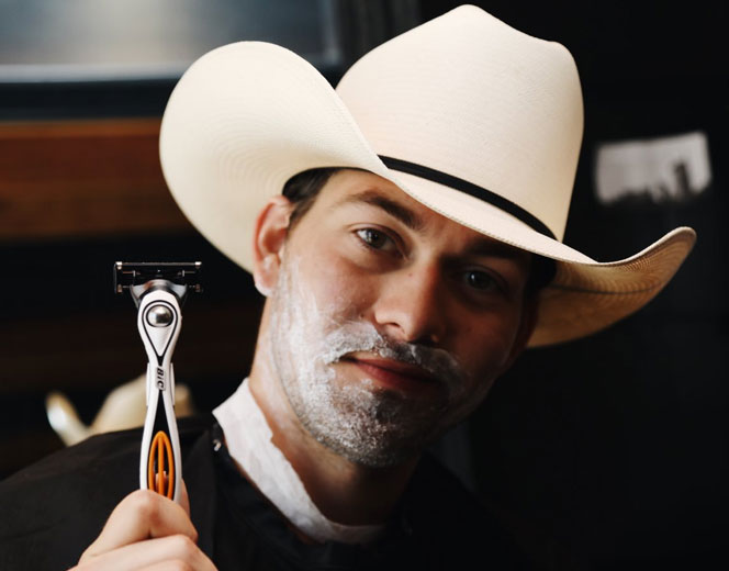 Country music artist holding a Bic Flex5hybrid razor at the Sip N’ Shave immersive barbershop and lounge, a promotional program created by  the HUNTER integrated marketing and PR firm in NYC.